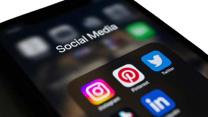 Smartphone-Bildschirm mit den Social-Media-Icons von Instagram, Facebook, TikTok, Pinterest, Twitter und LinkedIn unter der Überschrift "Social Media".